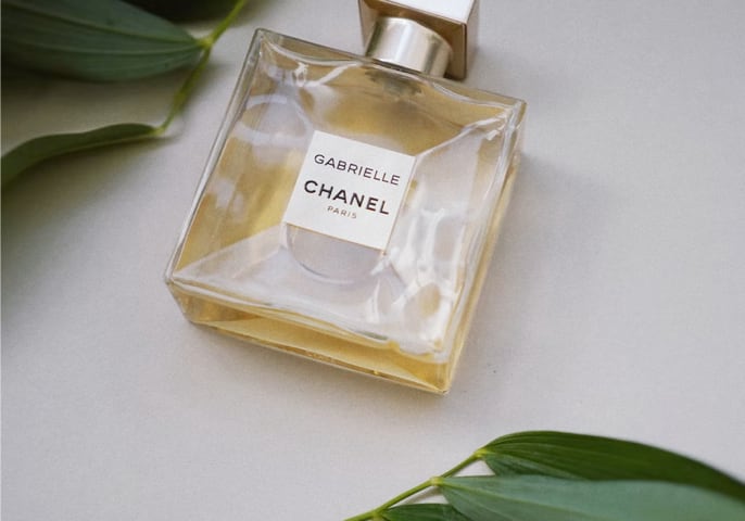 Clear perfume bottle with gold top filled with Gabrielle by Chanel